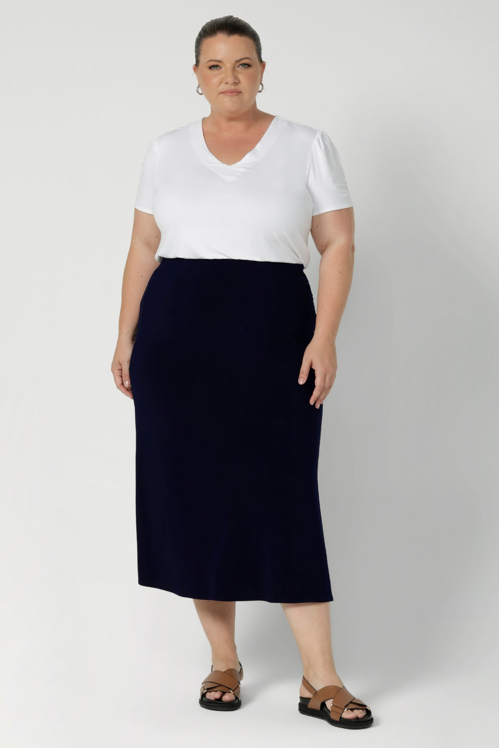 Whether you're dressing for the office or heading out on the go, this skirt serves as a reliable, stylish option that easily pairs with a range of tops, blouses, and jackets. Plus size model wears timeless design in deep blue colour. This Navy Midi Skirt is a versatile wardrobe essential—an ideal piece to keep you looking put-together and confident, wherever the day takes you. Available in size 8-24l 