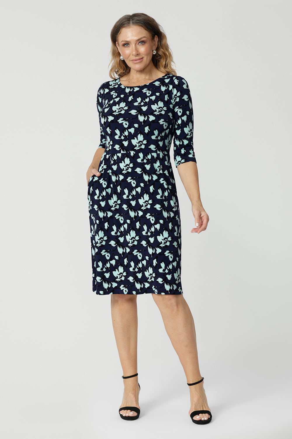 An over 40 woman wears a round neck shift dress in green and blue floral print. A good work wear dress for women, this jersey dress is made in Australia by Australian and New Zealand women's clothes brand, Leina & Fleur. Available in sizes 8 to 24, shop this comfortable work dress in plus size and petite sizes.