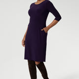 A size 10 woman wears the Audrey Dress in Amethyst. A purple Jersey dress with pockets made in Australia for women in size 8-24.