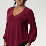 The Avery Top in Ruby brings effortless elegance to your everyday wardrobe, combining tailored structure with luxurious comfort. Crafted in Australia from a soft-stretch, dry-touch jersey fabric, this vibrant red women's top delivers both style and wearability. The semi-fitted silhouette features long bell sleeves with cuffs that add a touch of drama, while still maintaining a polished, versatile look.