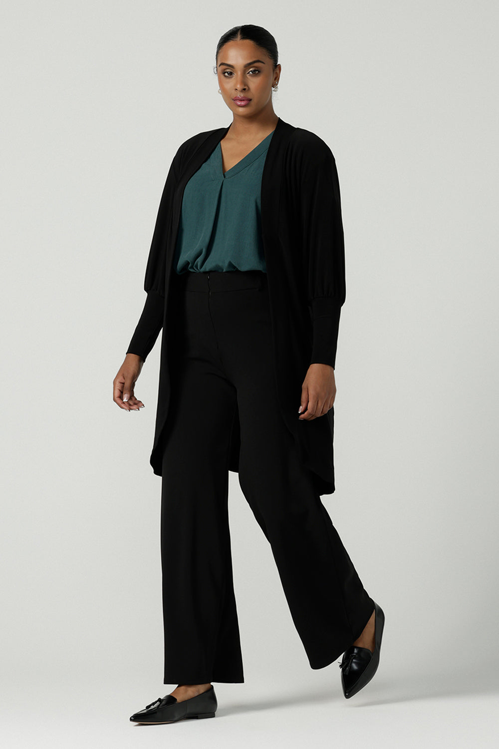 A size 10 woman wears the Bardon Duster in Black, a jersey cardigan with balloon sleeves and made in comfortable jersey. Petite to plus size and styled back with the Terry top in Alpine Tencel. 