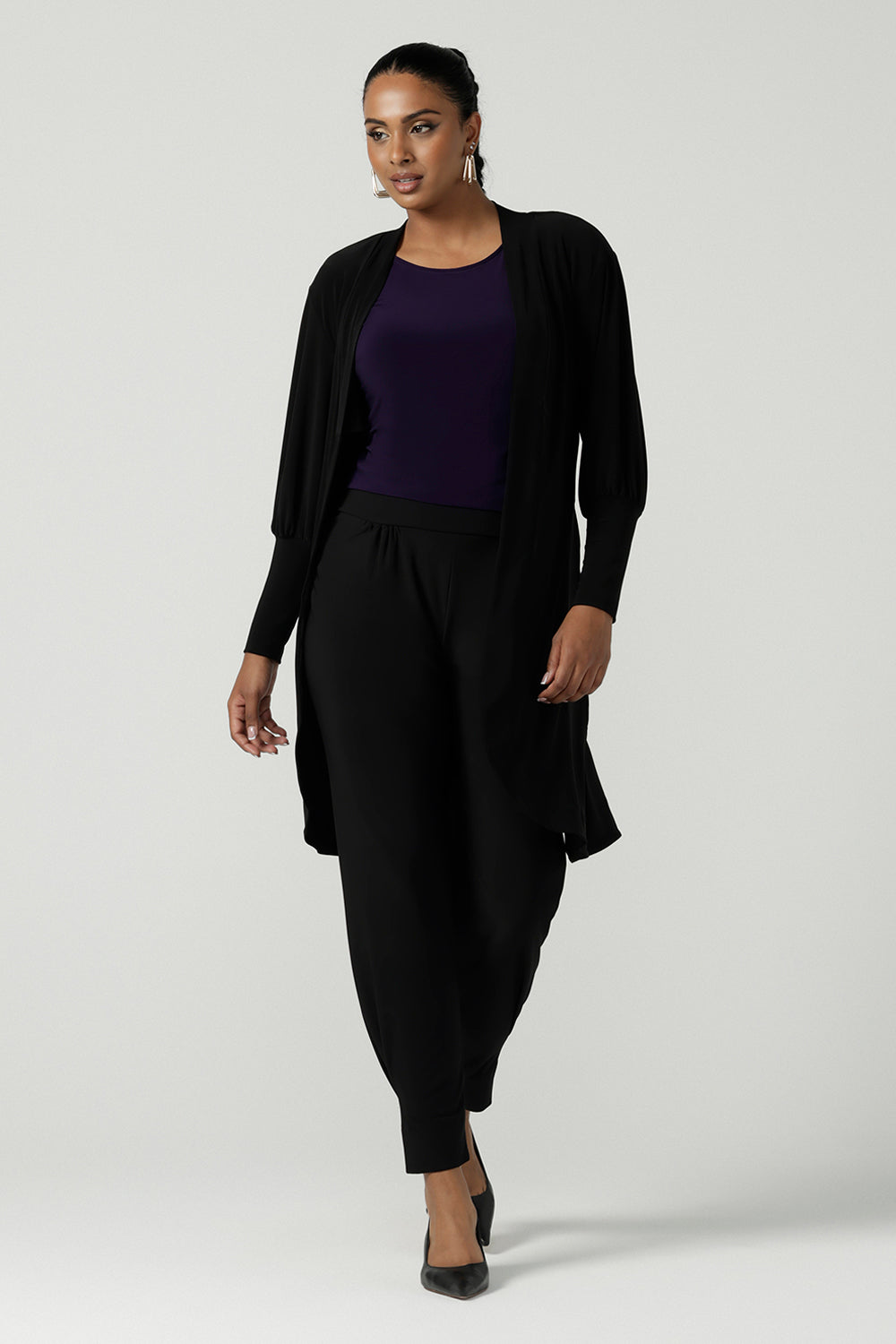 A size 10 woman wears the Bardon Duster in Black, a jersey cardigan with balloon sleeves and made in comfortable jersey. Petite to plus size and styled back with the Bardon Duster in Black. And amethyst top. 