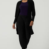 A size 10 woman wears the Bardon Duster in Black, a jersey cardigan with balloon sleeves and made in comfortable jersey. Petite to plus size and styled back with the Bardon Duster in Black. And amethyst top. 