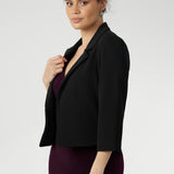 The single-layer back is shaped with delicate darts that contour the figure, while the shoulder yoke adds a structured element to the overall design.