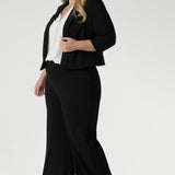 Size 18 woman wears black jacket that contours to the body for a flattering shape. 3/4 length sleeves with tucks at the sleeve heads add a unique, sophisticated detail that sets the jacket apart from traditional blazers