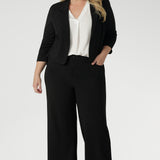 This black workwear cropped jacket exudes sophisticated, modern tailoring, crafted from a luxe Scuba Crepe fabric. The fabric’s soft, textured feel and slight stretch provide both comfort and a flattering fit. 