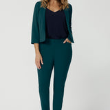 A good workwear outfit for over 40 women, a size 12 woman wears a cropped jacket in green scuba crepe jersey with a navy cami and tapered leg, green pants. Good pants for work, these trousers are made from stretchy jersey and are comfortable for all-day wear. Made in Australia by Australian and New Zealand women's clothes brand, Leina & Fleur, shop easy-care workwear for petite to plus size women. 