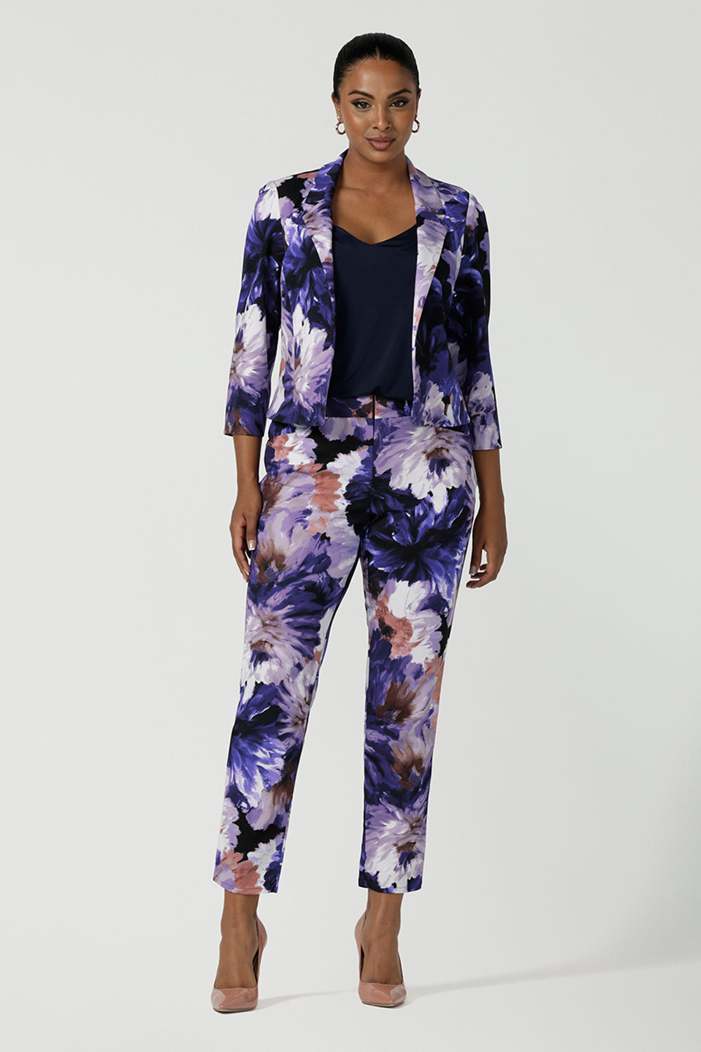 A size 10 woman wears a Benni Jacket in Jacaranda. With 3/4 sleeves and a floral purple print. Made in Australia for a size inclusive fashion label Leina & Fleur size 8-24.