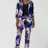 A size 10 woman wears a Benni Jacket in Jacaranda. With 3/4 sleeves and a floral purple print. Made in Australia for a size inclusive fashion label Leina & Fleur size 8-24.