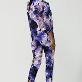 Back view of a size 10 woman wears a Benni Jacket in Jacaranda. With 3/4 sleeves and a floral purple print. Made in Australia for a size inclusive fashion label Leina & Fleur size 8-24.