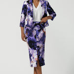 A size 10 woman wears a Benni Jacket in Jacaranda. With 3/4 sleeves and a floral purple print. Made in Australia for a size inclusive fashion label Leina & Fleur size 8-24.