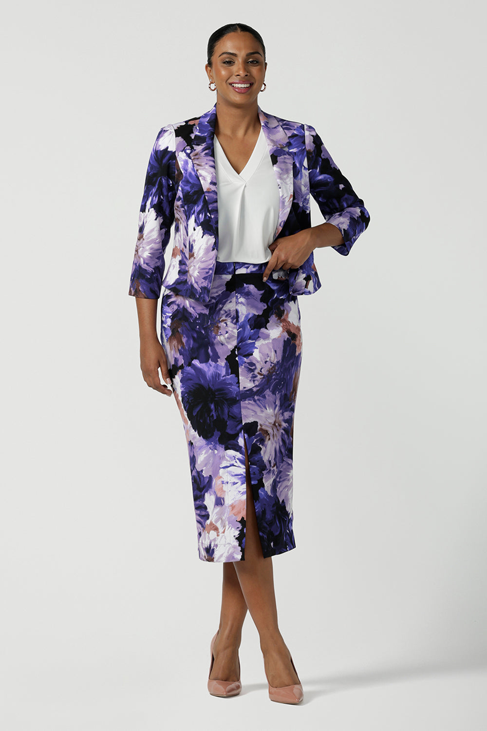 A size 10 woman wears a Benni Jacket in Jacaranda. With 3/4 sleeves and a floral purple print. Made in Australia for a size inclusive fashion label Leina & Fleur size 8-24.