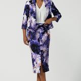 A size 10 woman wears a Benni Jacket in Jacaranda. With 3/4 sleeves and a floral purple print. Made in Australia for a size inclusive fashion label Leina & Fleur size 8-24.