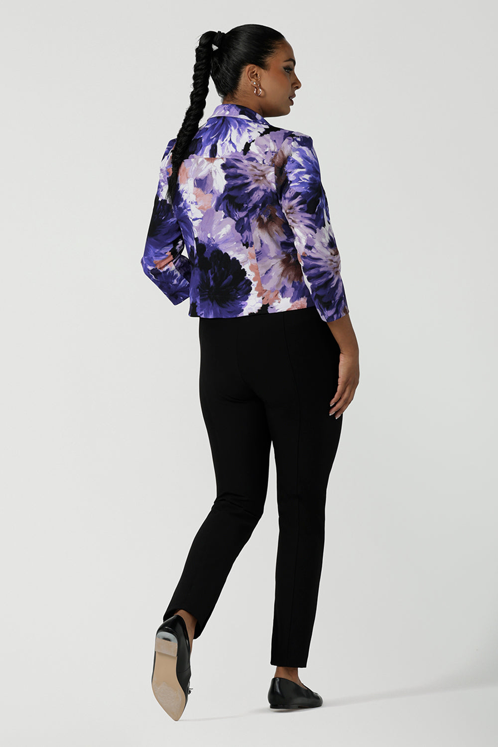 Back view of a size 10 woman wears a Benni Jacket in Jacaranda. With 3/4 sleeves and a floral purple print. Made in Australia for a size inclusive fashion label Leina & Fleur size 8-24.