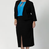 Size 18 woman wears black jacket that contours to the body for a flattering shape. A shoulder yoke further refines the jacket's structure, while the 3/4 length sleeves with tucks at the sleeve heads add a unique, sophisticated detail that sets the jacket apart from traditional blazers.