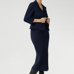 Inside, you'll find a practical phone pocket on the inner left side, perfect for easy access to essentials. The single-layer back is shaped with delicate darts that contour the figure, while the shoulder yoke adds a structured element to the overall design.