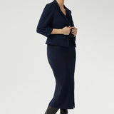 Inside, you'll find a practical phone pocket on the inner left side, perfect for easy access to essentials. The single-layer back is shaped with delicate darts that contour the figure, while the shoulder yoke adds a structured element to the overall design.