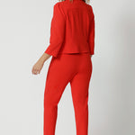 The jacket's back features a single layer with tailored darts, enhancing the fit and creating a feminine, contoured silhouette. A shoulder yoke further elevates the design, contributing to its polished, professional feel. The 3/4 length sleeves are subtly detailed with tucks at the sleeve heads, adding a touch of sophistication and texture to the overall look.