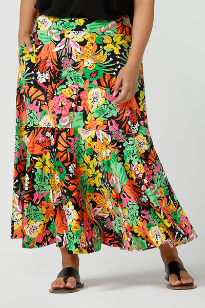  Close up of size 12 woman wears colourful and bright tiered Bert Skirt in Cancun. Soft jersey material with pockets. Styled with black cami top and carli shrug in black jersey. Designed and made in Australia size 8-24.