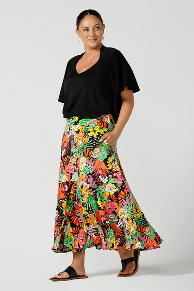  Size 12 woman wears colourful and bright tiered Bert Skirt in Cancun. Soft jersey material with pockets. Styled with black cami top and carli shrug in black jersey. Designed and made in Australia size 8-24.