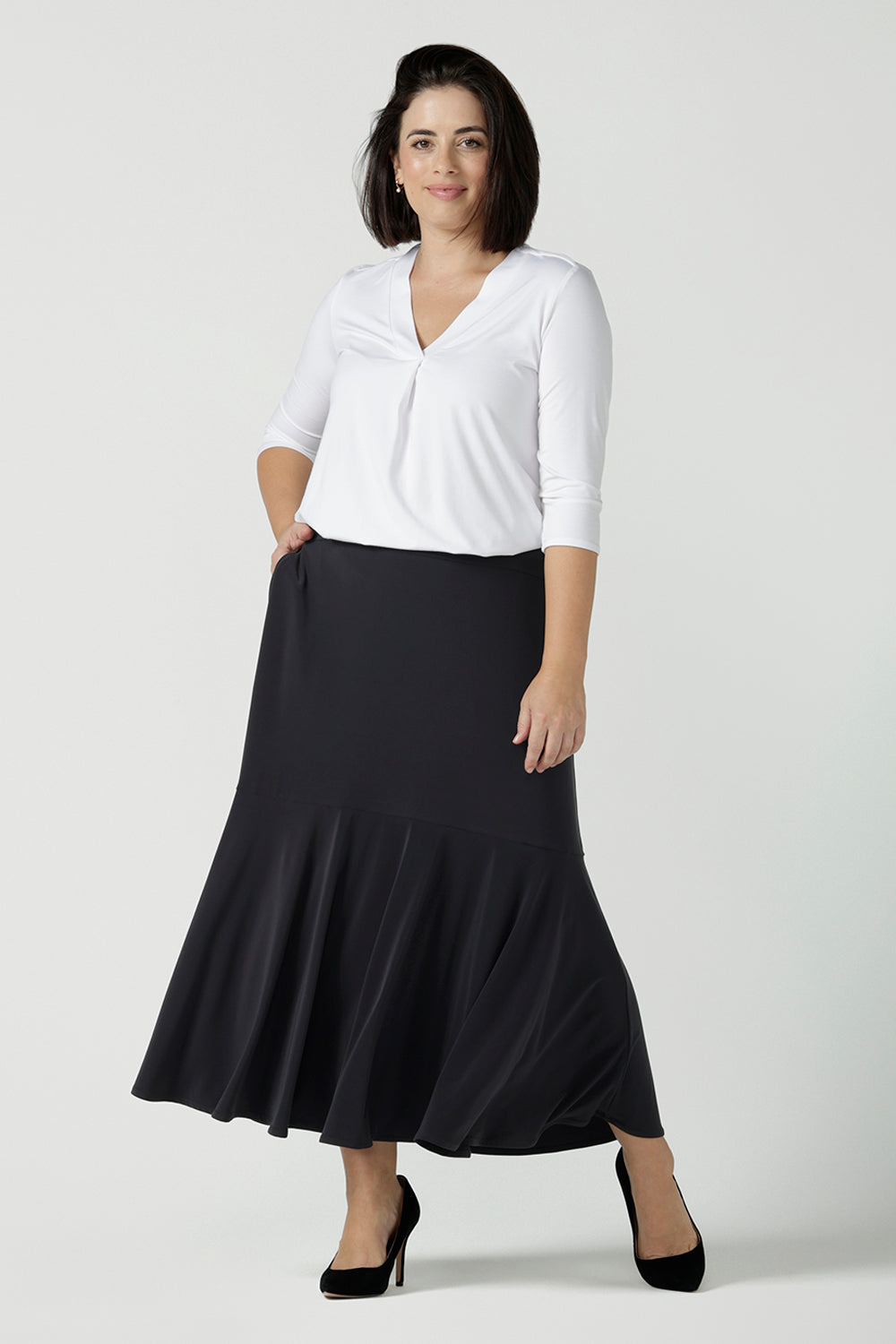 Size 10 wears the Berit Maxi skirt in Charcoal. A women's jersey work skirt with pockets in a charcoal colour. Made in Australia for women size 8 - 24. Styled back with the Jaime top in white bamboo with 3/4 sleeves.