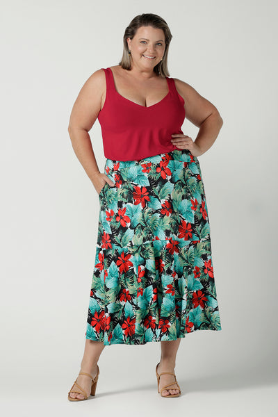 A size 18 curvy woman wears a Maxi Skirt in Havana print. Styled back with a red Kai cami top. The Berit Maxi skirt features a tier, a waistband and side pockets. Perfect for a weekend away or holiday capsule wardrobe. Made in Australia for women size 8 - 24.