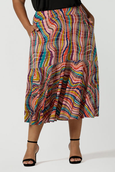 Close up of a curvy size 16 woman wears Berit Maxi skirt in Kaleidoscope. A rainbow coloured print with The Kaleidoscope print features a vibrant swirl of colour in all colours of the rainbow, pink, red, yellow, turquoise, brown and cobalt on a white base. Made in Australia for women size 8-24.