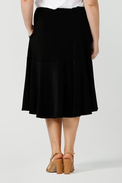 Back view of good workwear skirt for women. This knee-length, pull-on black skirt has pockets, a ruffle hemline and comfort waistband. A great addition to your capsule wardrobe, this black skirt is made by Australian made women's clothing brand, Leina & Fleur. Shop petite to plus size skirts in their online boutique in Australia. 
