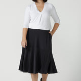 Size 10 Women wears the Berit skirt in Charcoal with pockets and tier hem. A great below knee length skirt perfect for all heights especially petite. Made in Australia for women size 8 - 24.