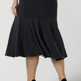 Close up of a size 10 Women wears the Berit skirt in Charcoal with pockets and tier hem. A great below knee length skirt perfect for all heights especially petite. Made in Australia for women size 8 - 24.