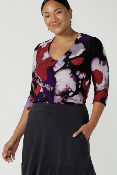 Size 10 woman wears the Vida top in Fitzroy with a V-neckline and 3/4 sleeve. Curved hemline and comfortable workwear for women made in Australia for women size 8 to 24. 