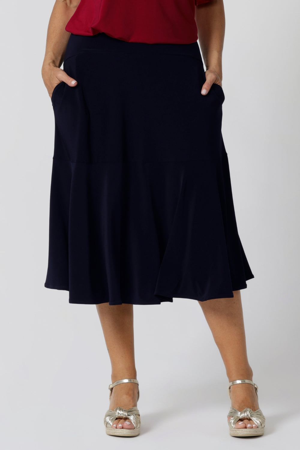 A great example of Australian-made skirts, this navy blue knee-length skirt in comfortable jersey fabric is shown in a size 12 as workwear for curvy women. Available from Australian ladies clothing brand, Leina & Fleur, this classic navy skirt is available as petite to plus size office wear in their online boutique.