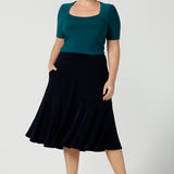 A great example of Australian-made skirts, this navy blue knee-length skirt in comfortable jersey fabric is worn with a fitted short sleeve top in teal. Available from Australian ladies clothing brand, Leina & Fleur, this classic navy skirt is available as petite to plus size office wear in their online boutique.