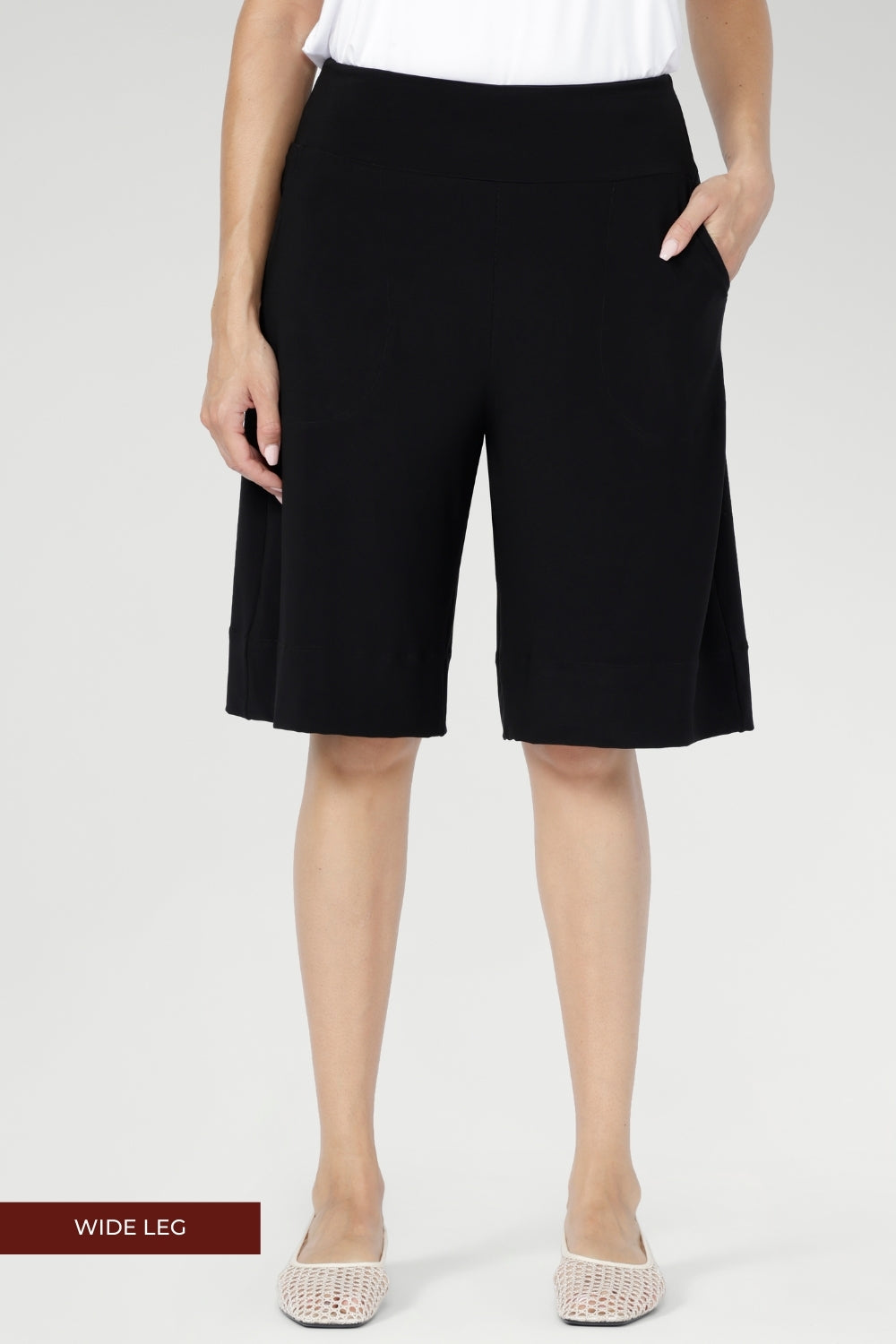 A double-layer waistband provides gentle support and a flattering fit, while side pockets with neat topstitching add both function and polish. The knee-length silhouette creates a balanced, versatile shape that feels relaxed yet considered.