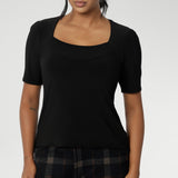 Over 30's woman wears short sleeve black top with square neckline. A slim fit top in classic black, this tailored jersey top wears well with workwear separates for an office look and also as a smart casual top. Shop tops online at Australian women's clothing brand, Leina & Fleur in sizes 8-24.