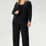 This short sleeve black jersey top is a must-have for women over 30 who appreciate timeless style and effortless versatility. Plus size woman wears her Berni Top in Black under charcoal coloured fluid suiting set, creating a comfortable yet corporate look.