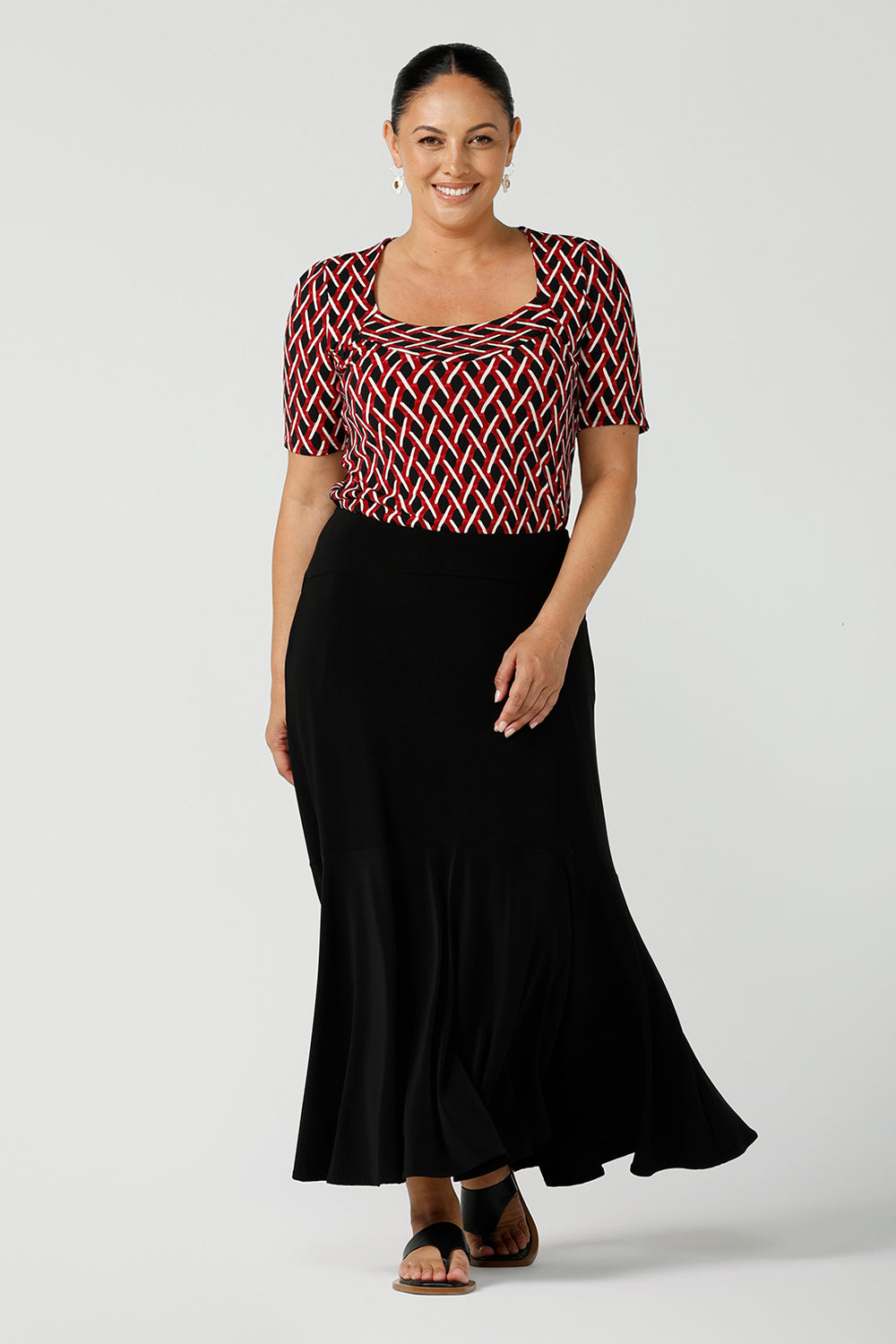 A size 12 woman wears a geometric Chevron print Berni top. Corporate causal work wear top that is comfortable and versatile. Styled back with Black Indi pants. Made in Australia for women size 8 - 24.