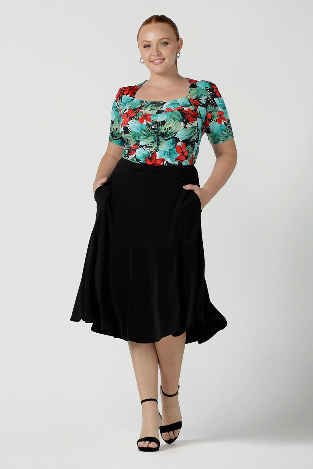 Size 12 curvy woman wears the Berni Top in Havana print. Square neckline with neck band and sleeve head tuck. Beautiful tropical print with red flowers and green palm leaves. Made in Australia for women size 8 - 24.