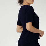 Size 10 woman wears a casual jersey top in navy blue. This Australian-made women's top has short fitted sleeves, a square neckline and and high-low - perfect for weekend casual and travel capsule wardrobes. Available in sizes 8-24. 