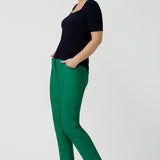 A size 10 over 40 year old woman wears a casual jersey top in navy blue, styled with emerald green pants. This Australian-made women's top has short fitted sleeves, a square neckline and and high-low - perfect for weekend casual and travel capsule wardrobes.