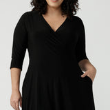 Close up of a size 16 Woman wears a Bettina Petite Reversible dress in black. A reversible dress for stylish casual wear. Soft stretch jersey with pockets and a wrap top. Made in Australia for women. Size 8 - 24.