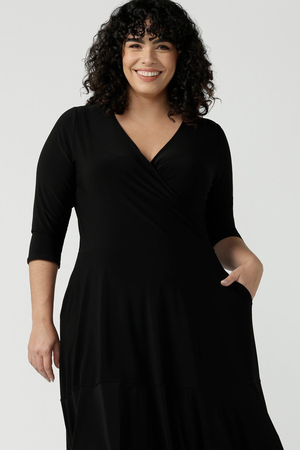 Close up of a size 16 Woman wears a Bettina Petite Reversible dress in black. A reversible dress for stylish casual wear. Soft stretch jersey with pockets and a wrap top. Made in Australia for women. Size 8 - 24.