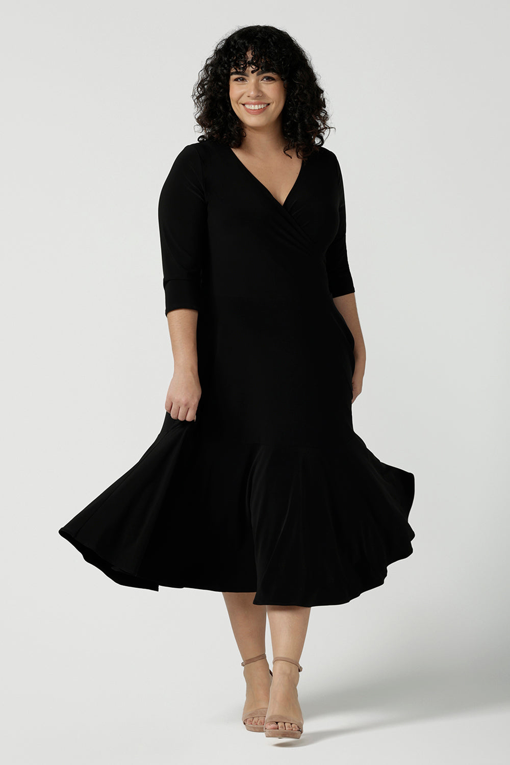 Size 16 Woman wears a Bettina Petite Reversible dress in black. A reversible dress for stylish casual wear. Soft stretch jersey with pockets and a wrap top. Made in Australia for women. Size 8 - 24.