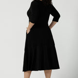 Back view of a close up of a size 16 Woman wears a Bettina Petite Reversible dress in black. A reversible dress for stylish casual wear. Soft stretch jersey with pockets and a wrap top. Made in Australia for women. Size 8 - 24.