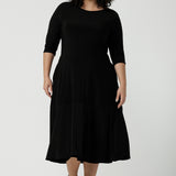 Reverse side of the Bettina dress in black, a size 16 Woman wears a Bettina Petite Reversible dress in black. A reversible dress for stylish casual wear. Soft stretch jersey with pockets and a wrap top. Made in Australia for women. Size 8 - 24.