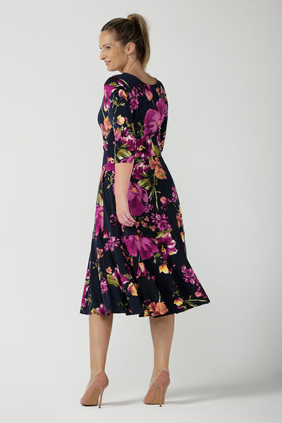 Back view of a size 10 Woman wears the Bettina Petite Reversible dress the Celeste print. It is a fixed wrap style with pockets and frill detail. A great work to wedding dress for women size 8 - 24.