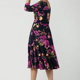 A size 10 Woman wears the Bettina Petite Reversible dress the Celeste print. It is a fixed wrap style with pockets and frill detail. A great work to wedding dress for women size 8 - 24. This is the dress featured on the reverse.