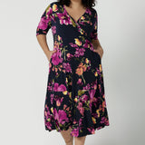 A size 18 Woman wears the Bettina Petite Reversible dress the Celeste print. It is a fixed wrap style with pockets and frill detail. A great work to wedding dress for women size 8 - 24.