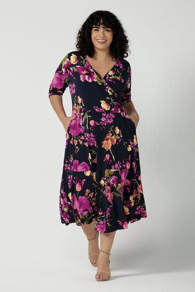 A size 18 Woman wears the Bettina Petite Reversible dress the Celeste print. It is a fixed wrap style with pockets and frill detail. A great work to wedding dress for women size 8 - 24.
