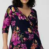 A size 18 Woman wears the Bettina Petite Reversible dress the Celeste print. It is a fixed wrap style with pockets and frill detail. A great work to wedding dress for women size 8 - 24. 